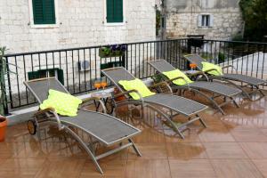 uma fila de cadeiras e mesas numa varanda em Apartment Bambina em Split