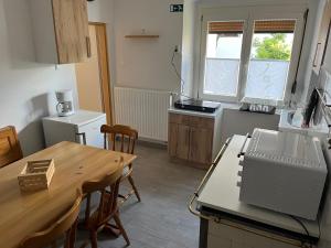 a kitchen with a wooden table and a counter top at Apartma GoDeTi in Rečica ob Savinji