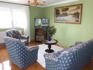 a living room with two chairs and a table and a television at Apartamento Casa Jeronimo in Taramundi
