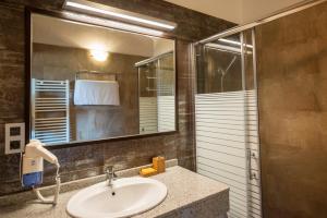 un bagno con lavandino e specchio di Casas Rurales Cuatro Valles a Naredo de Fenar Altre 118 foto