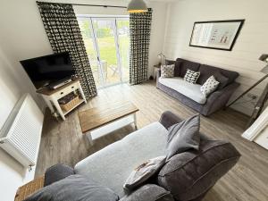a living room with a couch and a tv at Ocean Breeze in Filey