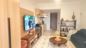 a living room with a blue couch and a flat screen tv at Peache house in Ruaka