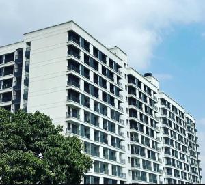 a large white apartment building with trees in the foreground at Peache house in Ruaka