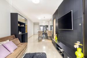 a living room with a couch and a flat screen tv at Apto 2Q - Churrasq. Garagem Perto da Praia LTL0301 in Meia Praia