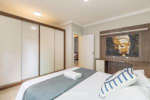 a bedroom with a large bed and a painting on the wall at Apto 2Q - Churrasq. Garagem Perto da Praia LTL0301 in Meia Praia