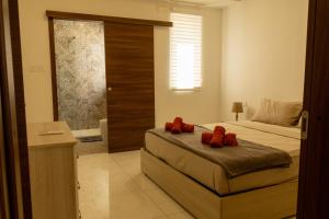 a bedroom with a bed with red pillows on it at Sunset and Seaview Apartment No 4 in Mellieħa