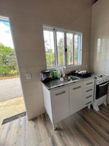 a kitchen with a sink and a stove at Chalés do vale Extrema verde in Extrema +34 photos