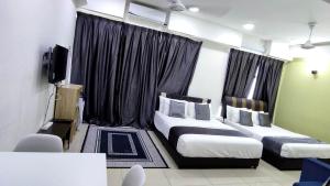 Una habitación de hotel con dos camas y un televisor. en Cahaya Qaira Homestay @ D'Perdana Kota Bharu, en Kota Bharu 130 fotos más