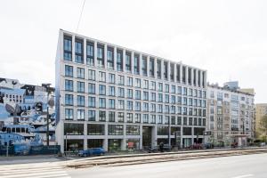 Un gran edificio blanco en una calle de la ciudad. en Chronos Luxury Apartments, en Varsovia