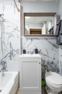 Un baño con lavabo, inodoro y espejo. en 1BR in the Heart of Downtown Boston Famous Nightlife Theater District with Bed Full of Promises TD Garden Common Park MBTA, en Boston 29 fotos más