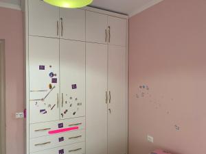 a white cabinet with stickers on it in a room at Delux Apartment in Pogradec