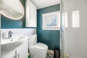 ein Badezimmer mit Toilette, Waschbecken und Spiegel in der Unterkunft Serene Kerrisdale Retreat, Private Room with Shared Amenities in Vancouver
