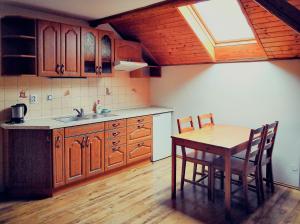 a kitchen with a table and chairs and a sink at Penzion Zvoneček in Jetřichovice +4 photos