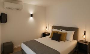 ein Schlafzimmer mit einem Bett mit Kissen und zwei Lampen in der Unterkunft Vilamoura Living 106 in Quarteira