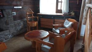 a room with chairs and a table and a window at Cabañas Aldea Lucerna La Cumbrecita in La Cumbrecita