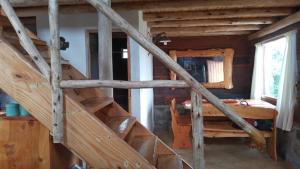 a wooden staircase in a log cabin with a bedroom at Cabañas Aldea Lucerna La Cumbrecita in La Cumbrecita