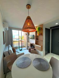 a living room with a table and a large light fixture at Beira-mar c/ Vista Mar | TKTU | Apt. 103 in Porto De Galinhas