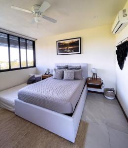 a bedroom with a white bed and a ceiling fan at Sunset 2BR Apartment Steps from the Beach with Ocean View in Holbox Island