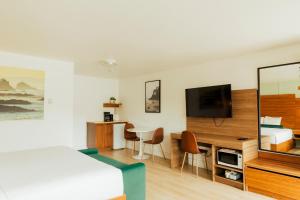 a hotel room with a bed and a television at Ucluelet Wildwood Inn in Ucluelet