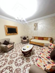 ein Wohnzimmer mit Sofa und Tisch in der Unterkunft Zoubeir's 3BR famille home-near shops&transport in tunis cité ettahrir in Bin Rhilouf