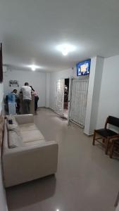 a man standing in a living room with a couch at Hotel Central La Jagua in La Jagua de Ibirico