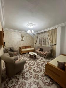 ein großes Wohnzimmer mit Sofas und einem Tisch in der Unterkunft Zoubeir's 3BR famille home-near shops&transport in tunis cité ettahrir in Bin Rhilouf