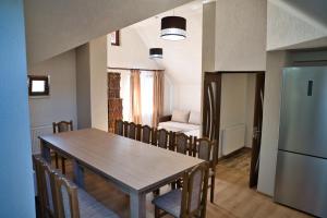 a kitchen and dining room with a table and chairs at Perla Argesului, hotel romantic elegant cu piscina, sport, petreceri, natura, curte, gradina, priveliste, parcare, cazare Transfăgarasan Curtea de Arges in Albestii de Arges