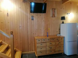 a kitchen with a refrigerator and a wooden wall at Domek dla rodziny in Jastarnia