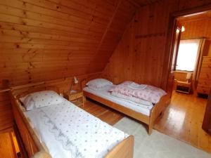 two beds in a room with wooden walls at Domek dla rodziny in Jastarnia