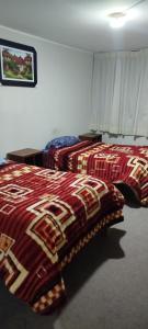 two beds in a hotel room with colorful blankets at HasREY in San Antonio