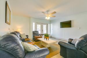 a living room with leather furniture and a ceiling fan at Walk to Beach Fort Meyers Home with Patio! in Fort Myers Beach