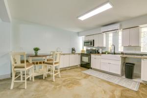 a kitchen with white cabinets and a table and chairs at Walk to Beach Fort Meyers Home with Patio! in Fort Myers Beach +18 photos