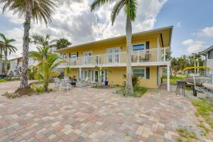 a house with palm trees and a patio at Walk to Beach Fort Meyers Home with Patio! in Fort Myers Beach