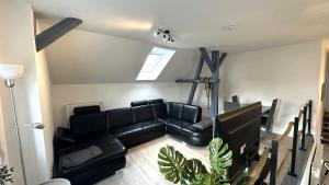 a living room with a black leather couch at Loft9 Architektenwohnung mit Dachterrasse Zentral in Lübeck
