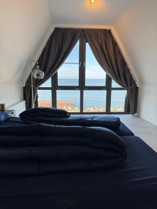 a bedroom with two beds and a large window at Enkhuizer Strand BeachHouse Panoramadeck mit Zaun Nr 415 in Enkhuizen