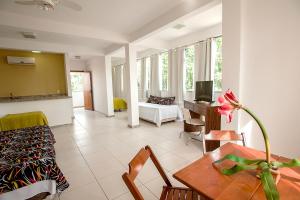 a living room with a table and a couch at Caiçara Flats in Cabo Frio