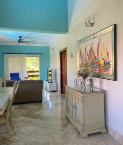 a living room with a couch and a painting on the wall at New! Chic Beach Condo at Punta Cana in Punta Cana +19 photos