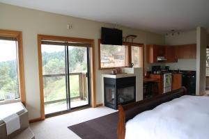 a bedroom with a bed and a fireplace and windows at Moon Water Lodge in Malahat