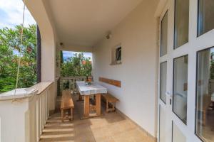 a small balcony with a table and bench on it at Apartments Mirela in Karlobag
