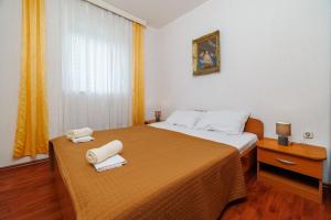 a hotel room with two beds with towels on them at Apartments Mirela in Karlobag