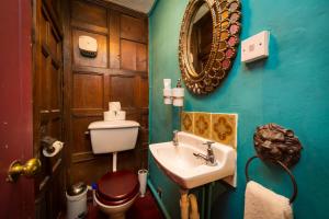 a bathroom with a toilet and a sink and a mirror at Trembling Madness Apartments in York