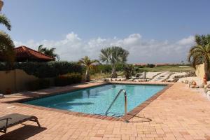 uma piscina com uma cadeira num resort em Perfect Sunset View em Palm-Eagle Beach