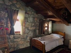 a bedroom with a bed in a stone wall at Hotel Panorama Zogaj in Zogaji