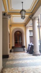 a hallway of a building with a door and columns at Dimora Storica in Milan