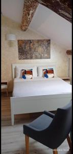 une chambre avec un lit blanc et une chaise dans l'établissement Dimora Storica, à Milan