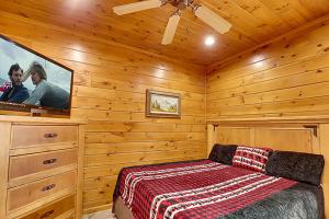 a bedroom with a bed and a flat screen tv at Elizabeths View II by Venture Smoky Mountains in Gatlinburg +15 photos