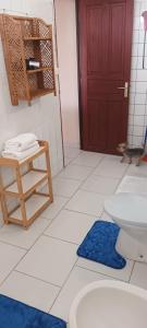 a bathroom with a toilet and a red door at Appart Vue Mer in Îlet à Christophe