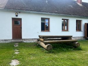 a white house with logs in front of it at Els-kwatawa Ranch in Reith