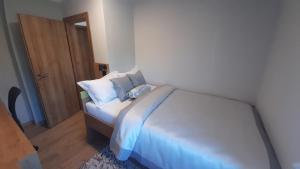 a bedroom with a bed with blue sheets and pillows at Apartman 4M in Ogulin