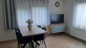 a dining room with a table with chairs and a television at Apartman 4M in Ogulin